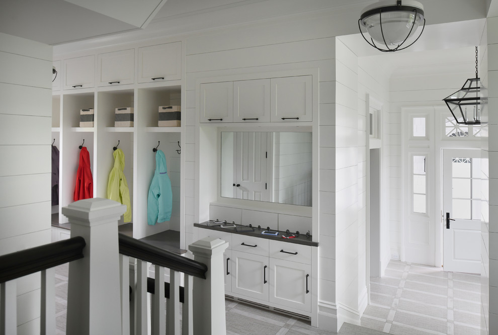 Photo of a country mudroom in New York with white walls, a single front door, a white front door and grey floor.