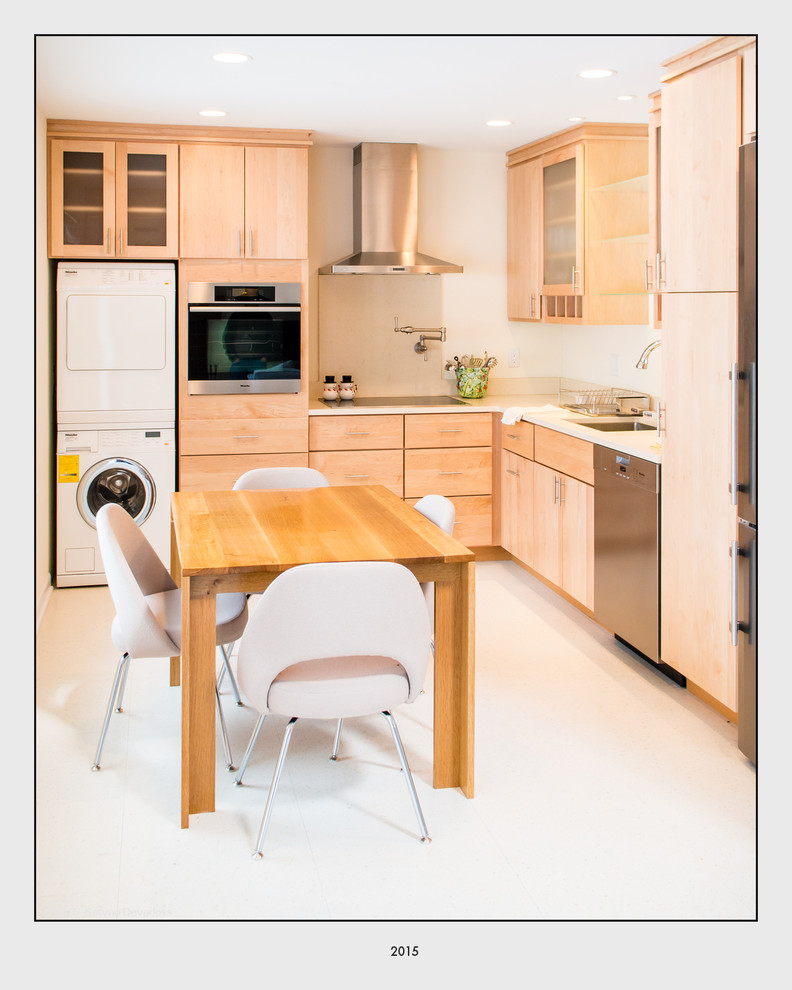 This is an example of a small contemporary l-shaped eat-in kitchen in Boston with an undermount sink, flat-panel cabinets, light wood cabinets, stainless steel appliances, vinyl floors and no island.