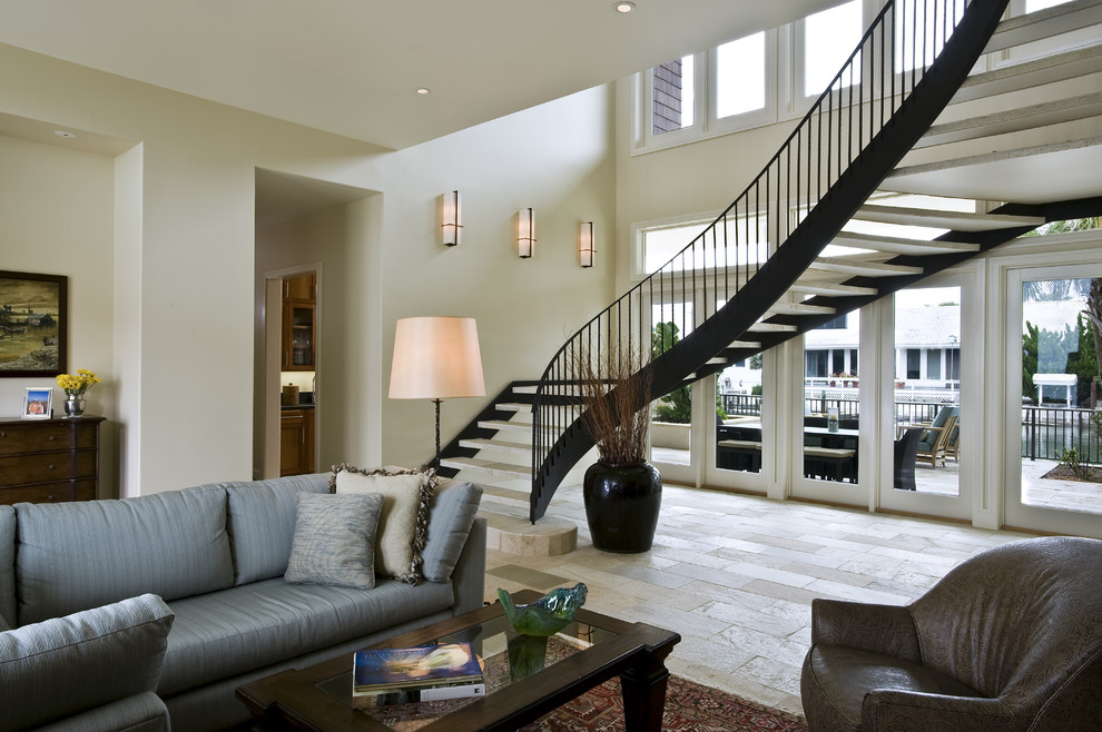 This is an example of a large contemporary limestone curved staircase in Austin with open risers and metal railing.