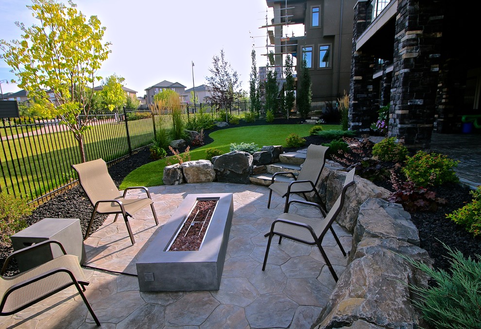 Photo of a large rustic partial sun backyard brick landscaping in Edmonton with a fire pit for summer.