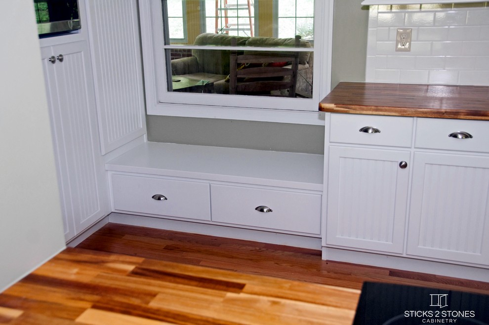 Inspiration for a small timeless galley light wood floor open concept kitchen remodel with a double-bowl sink, shaker cabinets, white cabinets, wood countertops, white backsplash, subway tile backsplash, stainless steel appliances, green walls and a peninsula