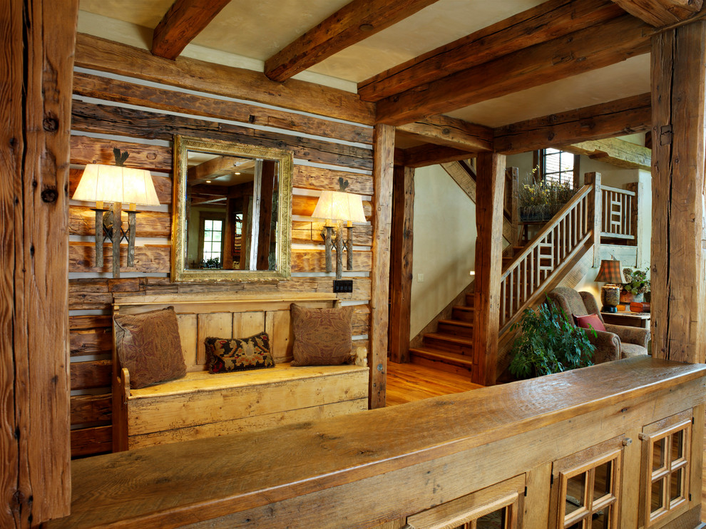 Inspiration for a large rustic medium tone wood floor foyer remodel in Denver with beige walls