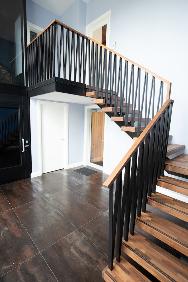This is an example of a mid-sized contemporary wood floating staircase in Auckland with open risers and metal railing.
