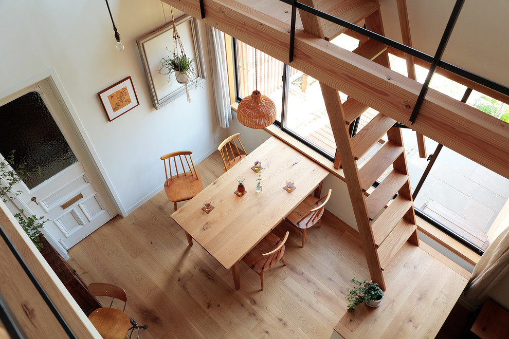 This is an example of a scandinavian open plan dining in Yokohama with white walls and medium hardwood floors.