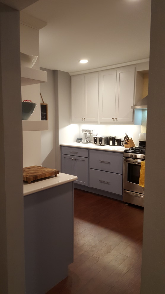 Inspiration for a mid-sized transitional u-shaped vinyl floor enclosed kitchen remodel with a farmhouse sink, recessed-panel cabinets, blue cabinets, quartz countertops, stainless steel appliances and a peninsula