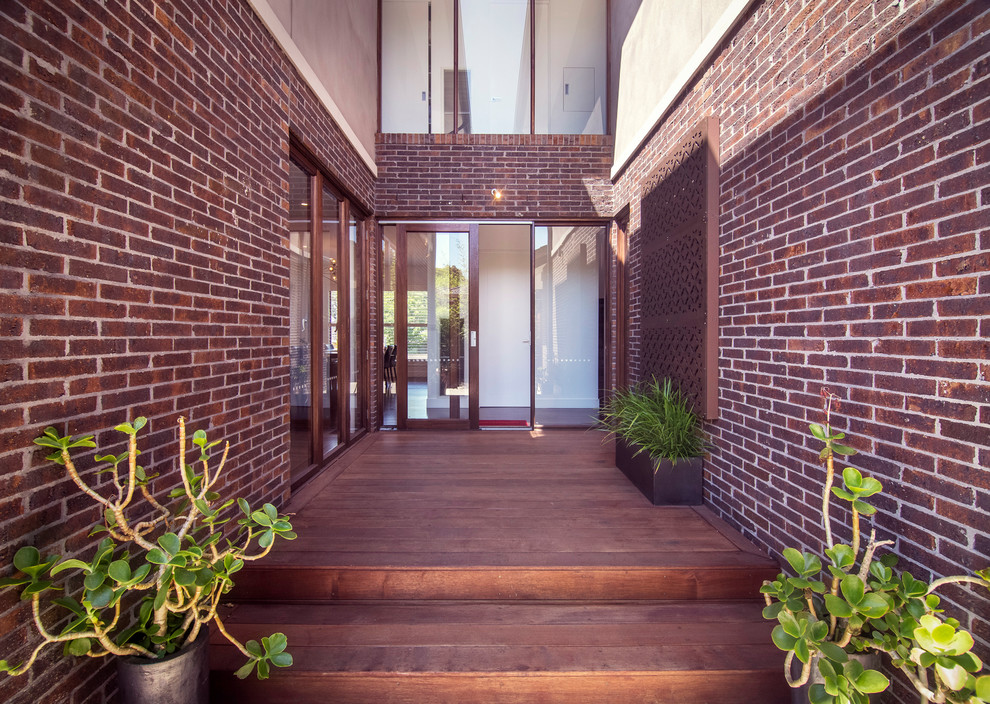 This is an example of a large contemporary side yard deck in Melbourne with no cover.