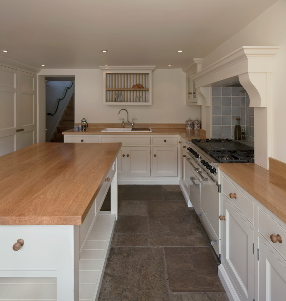 This is an example of a country kitchen in London with a farmhouse sink, shaker cabinets and beige cabinets.