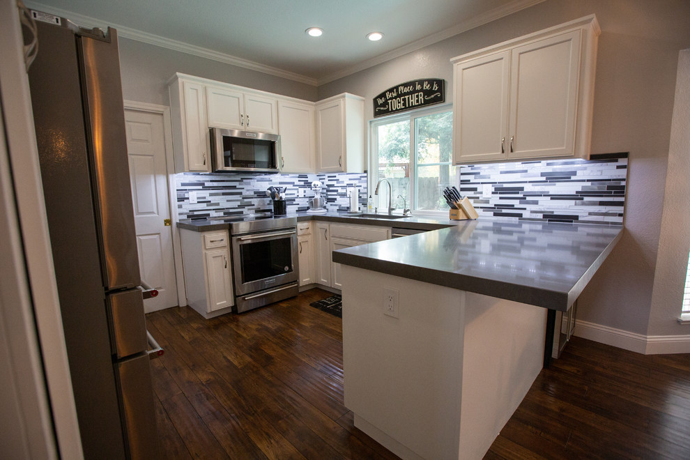 Mid-sized modern u-shaped eat-in kitchen in Sacramento with a single-bowl sink, white cabinets, quartz benchtops, mosaic tile splashback, stainless steel appliances and grey benchtop.
