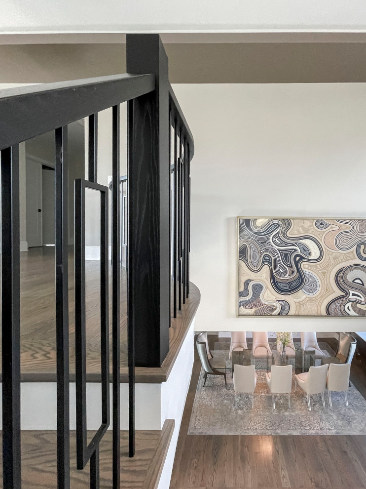 This is an example of an expansive traditional wood curved mixed railing staircase in DC Metro with painted wood risers and wallpapered walls.
