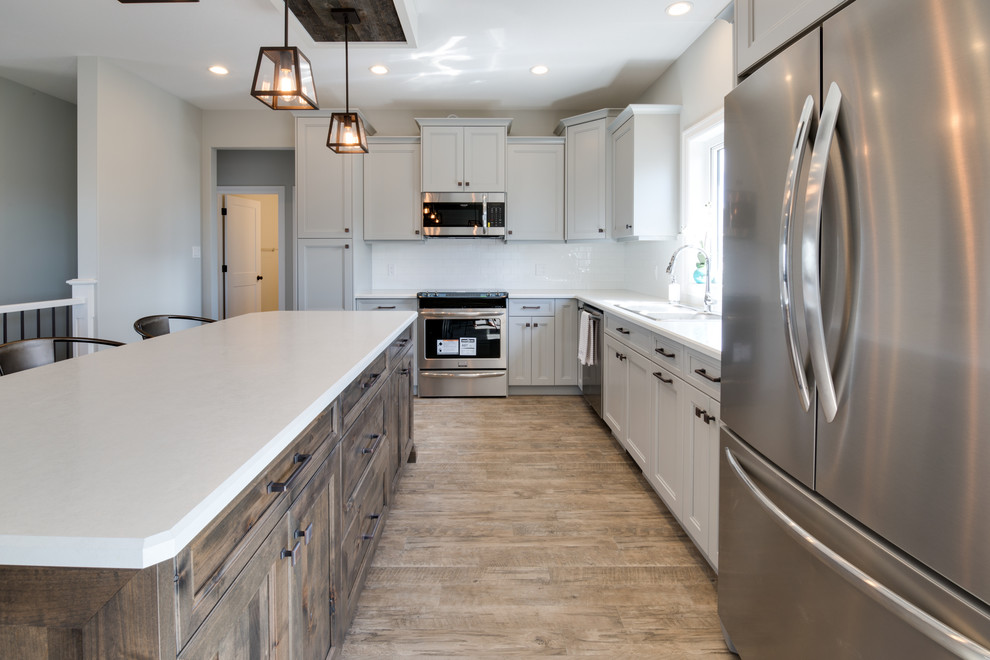 Example of a large transitional l-shaped open concept kitchen design with shaker cabinets, gray cabinets, laminate countertops, stainless steel appliances and an island