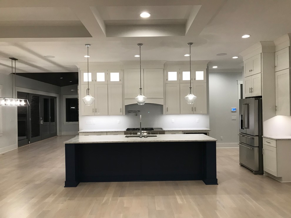 Example of a mid-sized transitional l-shaped light wood floor and beige floor open concept kitchen design in Cincinnati with an undermount sink, shaker cabinets, white cabinets, granite countertops, stainless steel appliances, an island and gray countertops