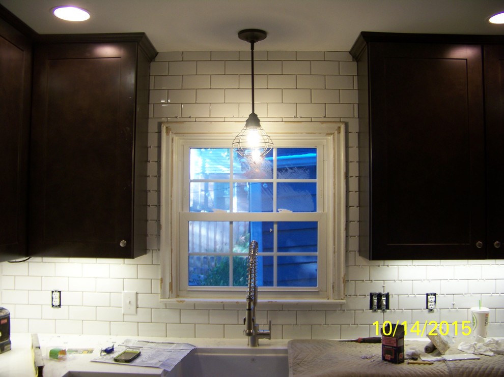 Mid-sized mountain style u-shaped porcelain tile eat-in kitchen photo in Indianapolis with a farmhouse sink, shaker cabinets, dark wood cabinets, wood countertops, white backsplash, ceramic backsplash, stainless steel appliances and an island