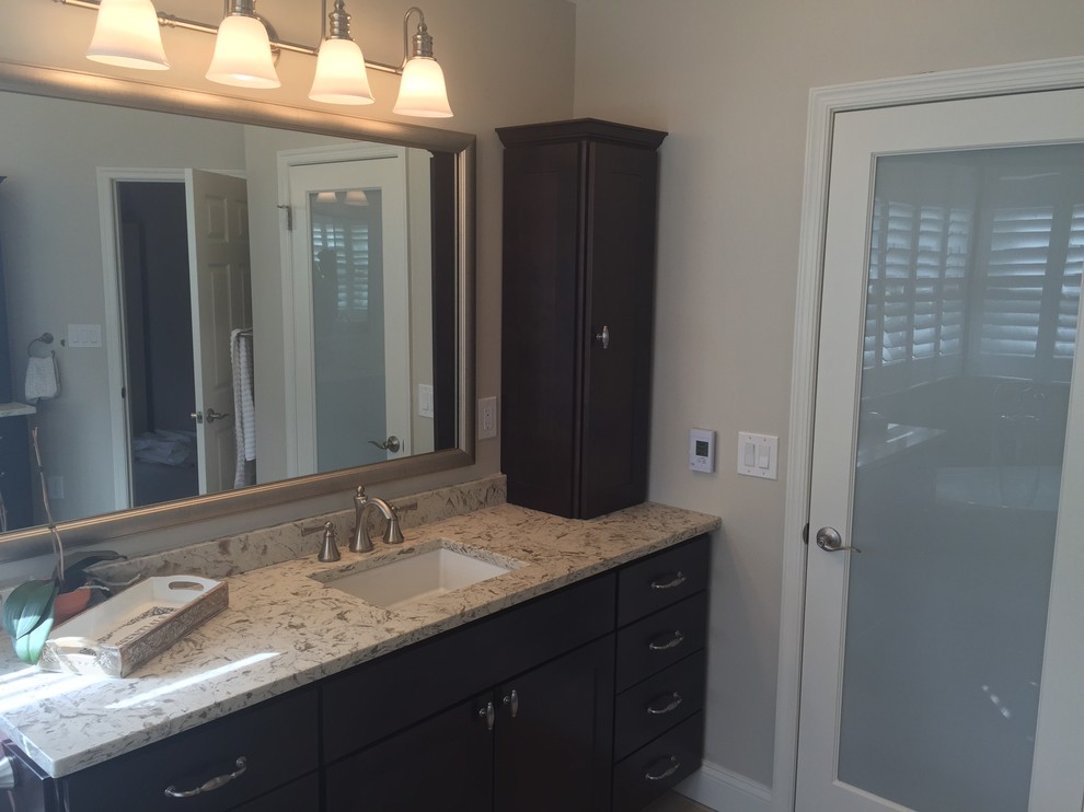 Inspiration for a large transitional master gray tile and porcelain tile light wood floor and brown floor freestanding bathtub remodel in Baltimore with shaker cabinets, dark wood cabinets, a two-piece toilet, beige walls, an undermount sink, solid surface countertops and a hinged shower door