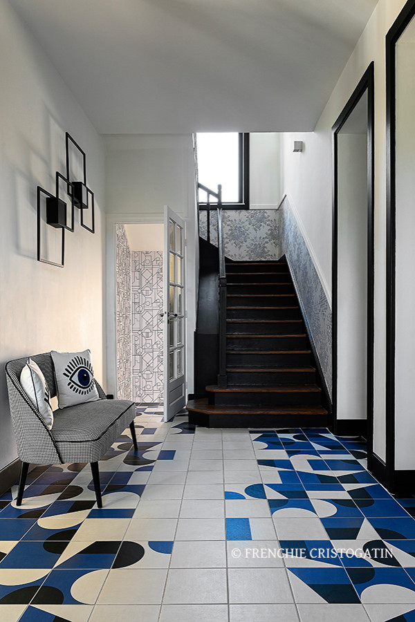 Photo of a foyer in Lyon with white walls and ceramic floors.