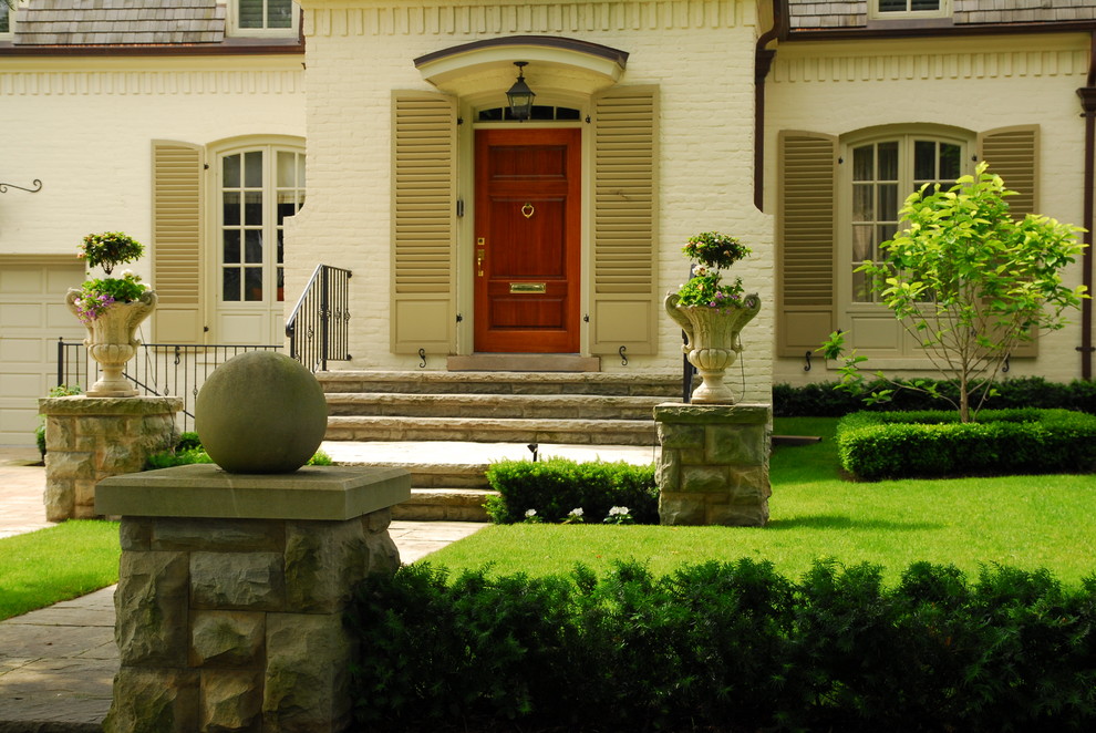 This is an example of a mid-sized traditional front yard shaded formal garden for spring in Toronto with natural stone pavers.