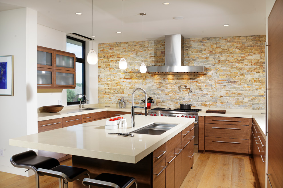 Photo of a contemporary u-shaped kitchen in Los Angeles with an undermount sink, flat-panel cabinets, dark wood cabinets, multi-coloured splashback, stone tile splashback and panelled appliances.