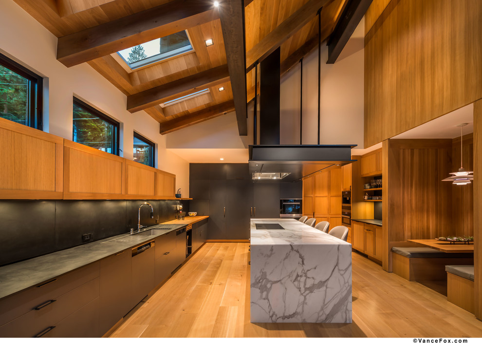 Large contemporary galley open plan kitchen in Other with an undermount sink, flat-panel cabinets, grey cabinets, quartz benchtops, grey splashback, panelled appliances, medium hardwood floors, with island, brown floor and grey benchtop.