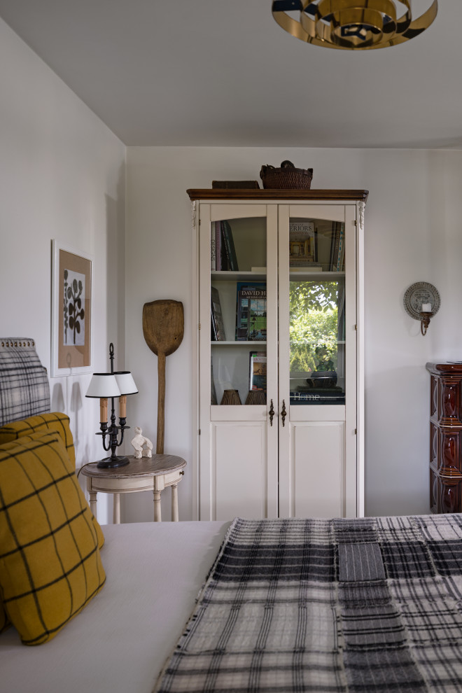 Kleines Nordisches Hauptschlafzimmer mit weißer Wandfarbe, gebeiztem Holzboden, Kamin, gefliester Kaminumrandung, weißem Boden, Kassettendecke und vertäfelten Wänden in Sonstige