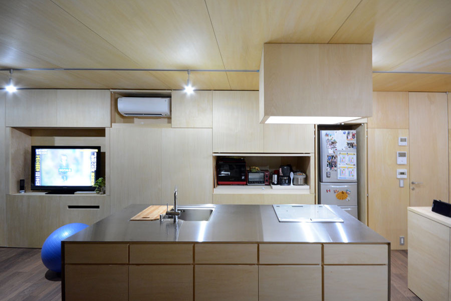 Idéer för ett litet grå linjärt kök med öppen planlösning, med en undermonterad diskho, luckor med profilerade fronter, skåp i ljust trä, bänkskiva i rostfritt stål, mörkt trägolv och en köksö