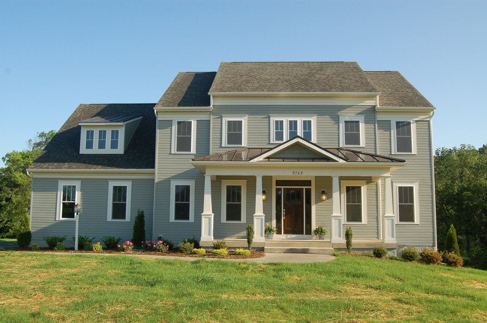 This is an example of a large traditional two-storey grey exterior in DC Metro with wood siding and a gable roof.