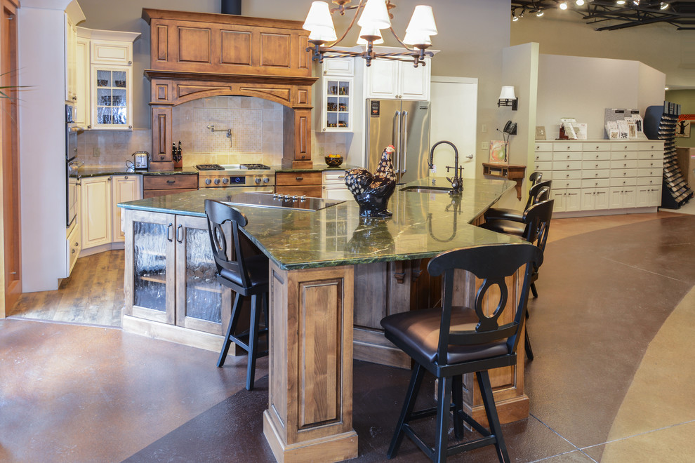 Mid-sized mountain style l-shaped concrete floor eat-in kitchen photo with an undermount sink, recessed-panel cabinets, blue cabinets, solid surface countertops, gray backsplash, porcelain backsplash, stainless steel appliances and an island