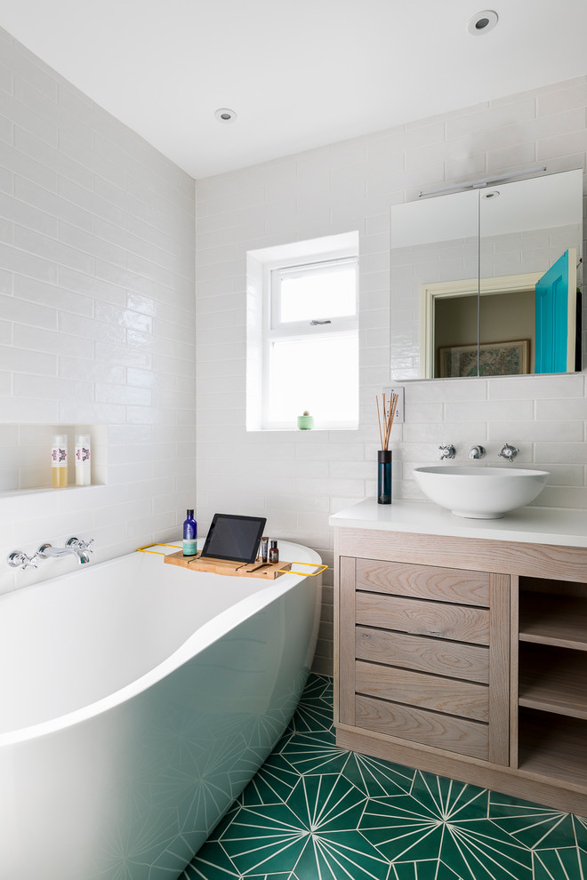 Design ideas for a small contemporary 3/4 bathroom in London with flat-panel cabinets, light wood cabinets, a freestanding tub, a wall-mount toilet, beige tile, porcelain tile, beige walls, porcelain floors, a vessel sink, solid surface benchtops, green floor and an open shower.