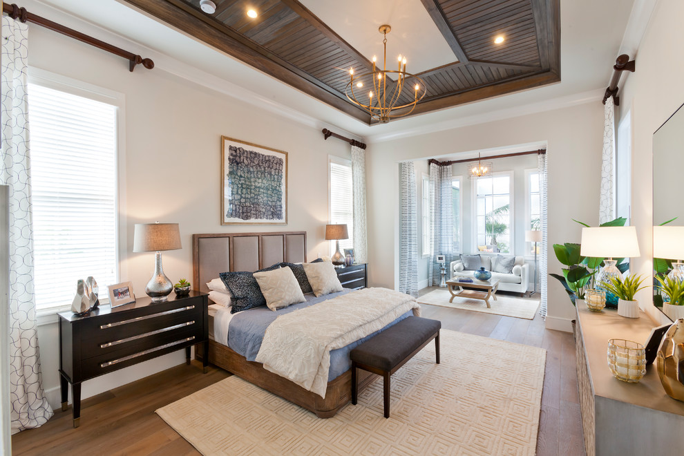 Inspiration for an expansive tropical master bedroom in Tampa with beige walls, medium hardwood floors and brown floor.