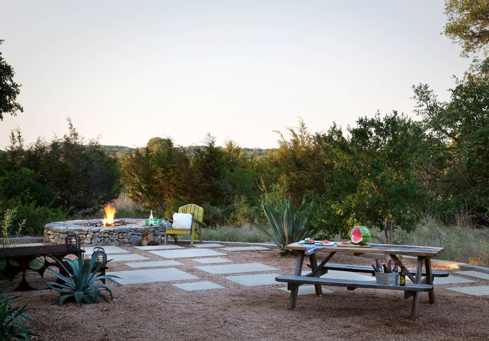 Photo of a country garden in Austin with a fire feature and gravel.