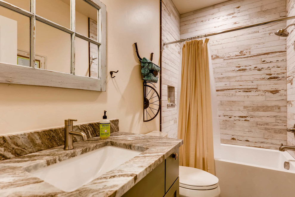 Small eclectic bathroom in Denver with shaker cabinets, green cabinets, a drop-in tub, a two-piece toilet, white tile, ceramic tile, beige walls, an undermount sink and granite benchtops.