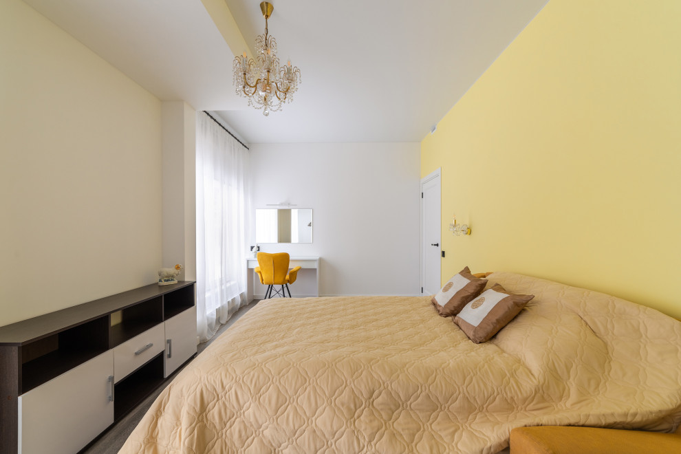 Стильный дизайн: большая хозяйская спальня в стиле модернизм с желтыми стенами, полом из ламината, коричневым полом, многоуровневым потолком и акцентной стеной без камина - последний тренд