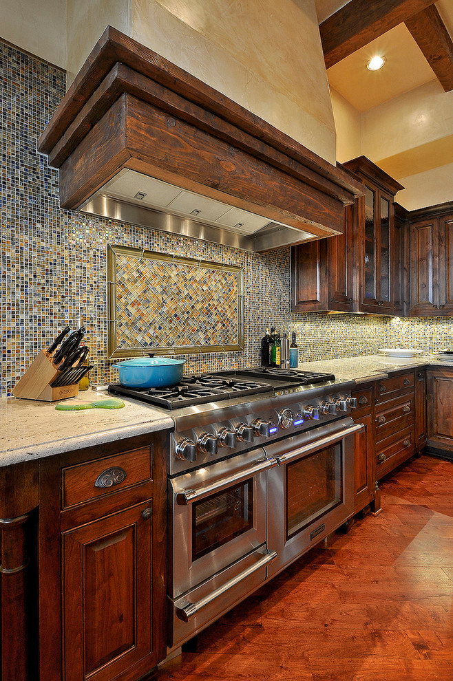 Inspiration for a huge rustic u-shaped medium tone wood floor eat-in kitchen remodel in Austin with a drop-in sink, granite countertops, multicolored backsplash, ceramic backsplash, paneled appliances and an island