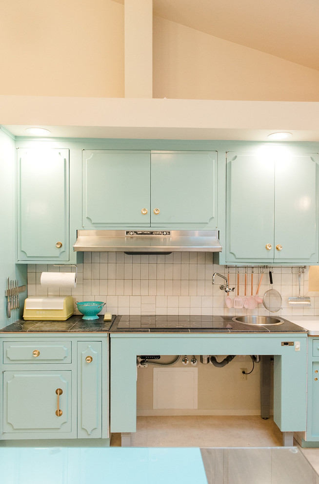 Transitional l-shaped eat-in kitchen in San Francisco with an undermount sink, turquoise cabinets, beige splashback, ceramic splashback, stainless steel appliances, porcelain floors, with island, multi-coloured floor and white benchtop.