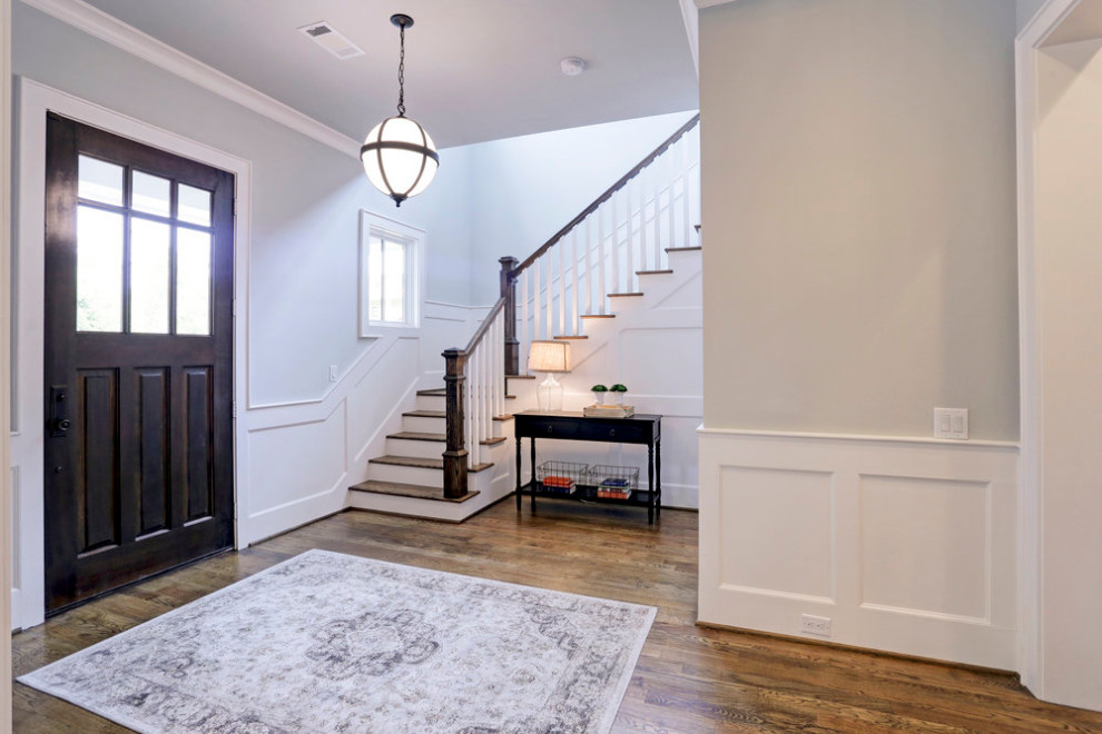 Photo of a small arts and crafts foyer in Houston with grey walls, medium hardwood floors, a single front door, a brown front door, brown floor and decorative wall panelling.