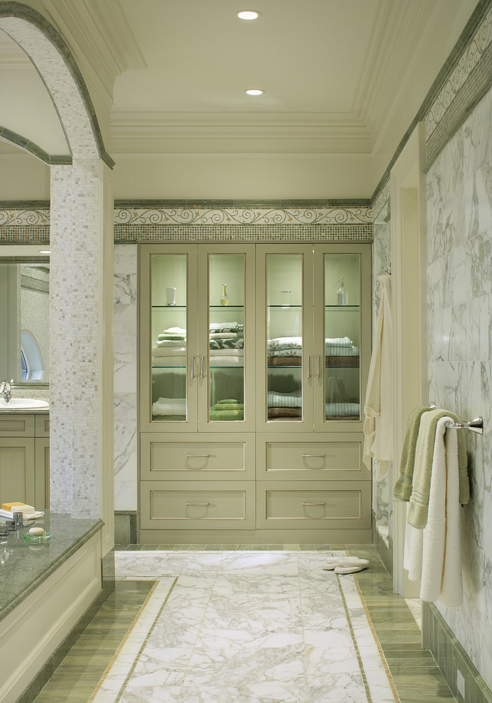 This is an example of a traditional bathroom in New York with a drop-in tub and marble floors.