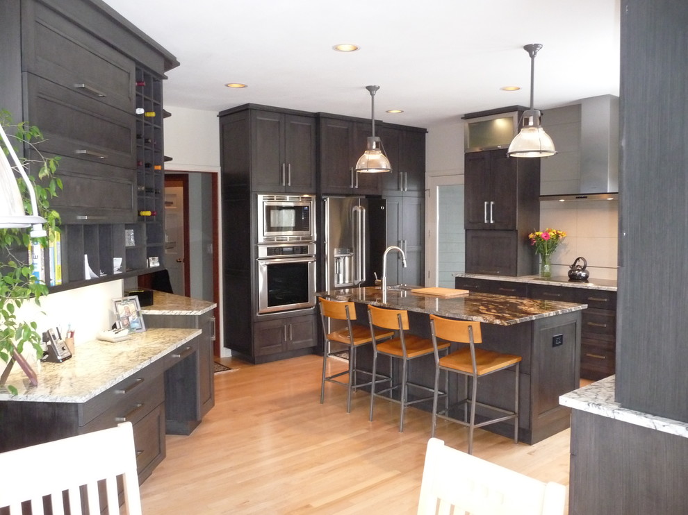 Eat-in kitchen - large transitional u-shaped light wood floor eat-in kitchen idea in Milwaukee with an undermount sink, flat-panel cabinets, gray cabinets, granite countertops, white backsplash, porcelain backsplash, stainless steel appliances and an island