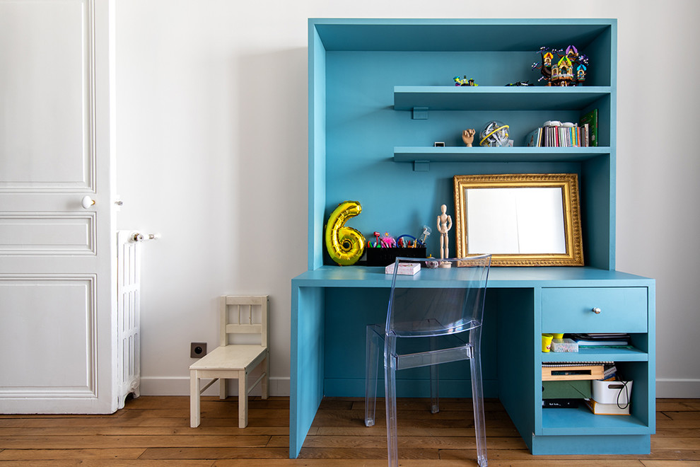 Photo of a mid-sized transitional gender-neutral kids' room for kids 4-10 years old in Paris with white walls, light hardwood floors and brown floor.
