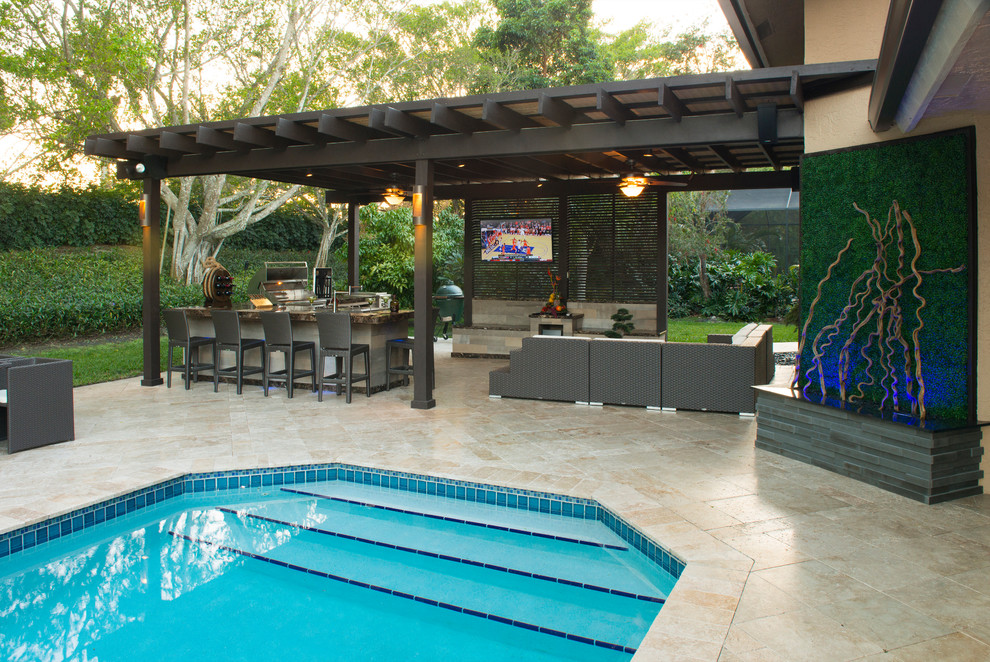 Photo of an expansive traditional backyard patio in Miami with an outdoor kitchen, natural stone pavers and a pergola.