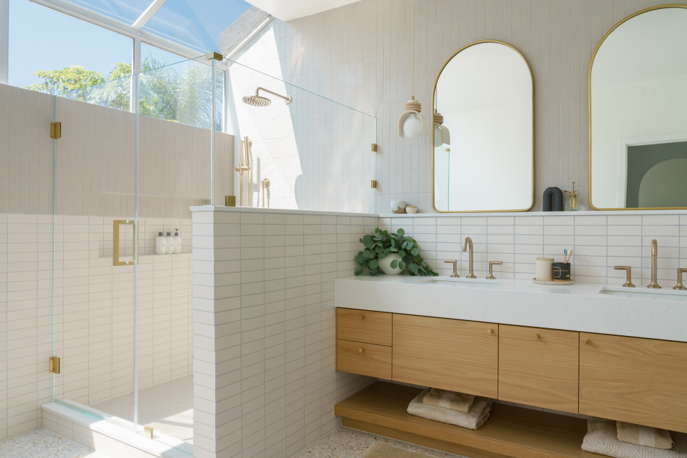 Inspiration for a contemporary bathroom in Orange County with flat-panel cabinets, medium wood cabinets, an undermount sink, beige floor, a hinged shower door, white benchtops, a double vanity and a floating vanity.