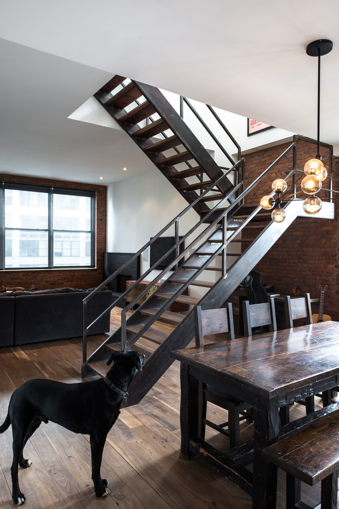 Mid-sized industrial wood u-shaped staircase in New York with open risers and metal railing.