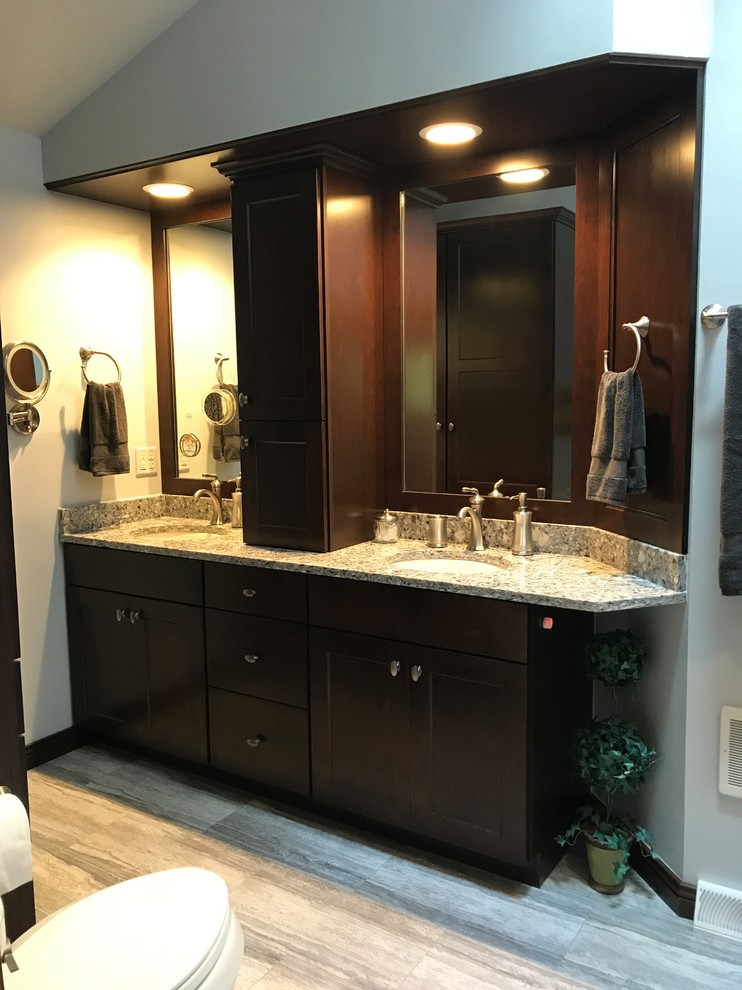 Inspiration for a mid-sized transitional master gray tile gray floor bathroom remodel in Milwaukee with shaker cabinets, dark wood cabinets, a two-piece toilet, gray walls, an undermount sink and quartz countertops