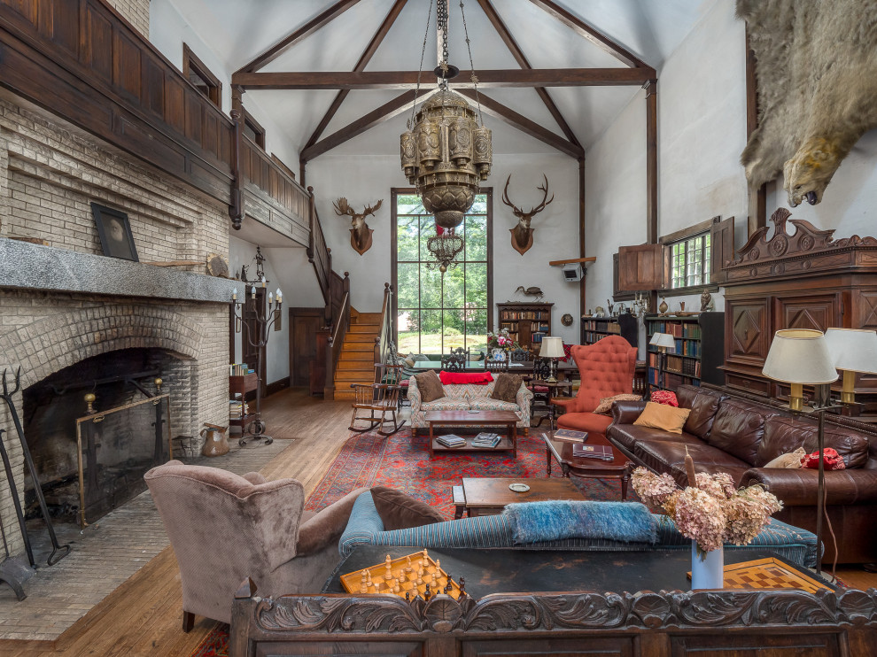 Huge country open concept medium tone wood floor family room photo in Portland Maine with white walls, a standard fireplace and a brick fireplace