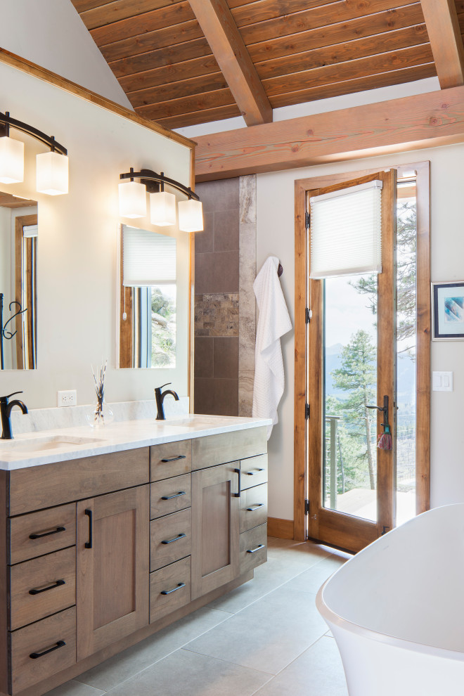 Photo of a country master bathroom in Denver with dark wood cabinets, a freestanding tub, white walls, an undermount sink, grey floor, white benchtops, a double vanity, a freestanding vanity, exposed beam, vaulted and wood.