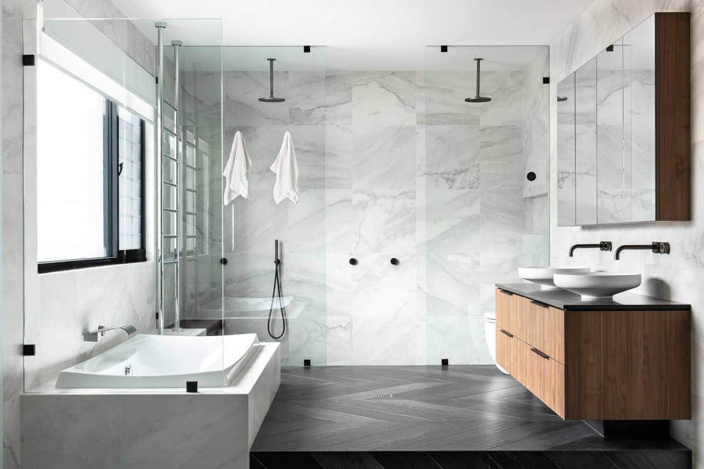 Photo of a large contemporary master bathroom in Perth with flat-panel cabinets, medium wood cabinets, a drop-in tub, a double shower, white tile, marble, porcelain floors, granite benchtops, black floor, an open shower, black benchtops, a niche, a double vanity, a floating vanity and a vessel sink.