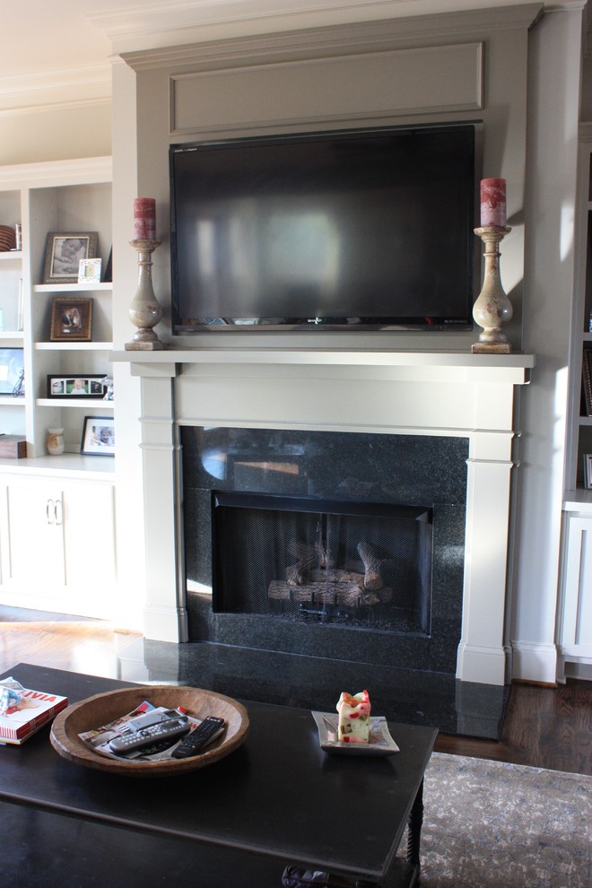 Photo of a mid-sized traditional open concept living room in Birmingham with grey walls, medium hardwood floors, a standard fireplace, a tile fireplace surround and a wall-mounted tv.