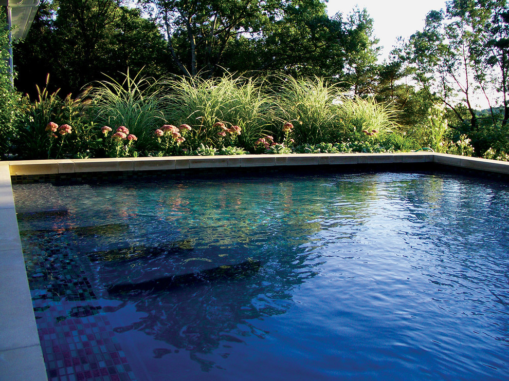 Contemporary backyard rectangular lap pool in Boston with a water feature and natural stone pavers.