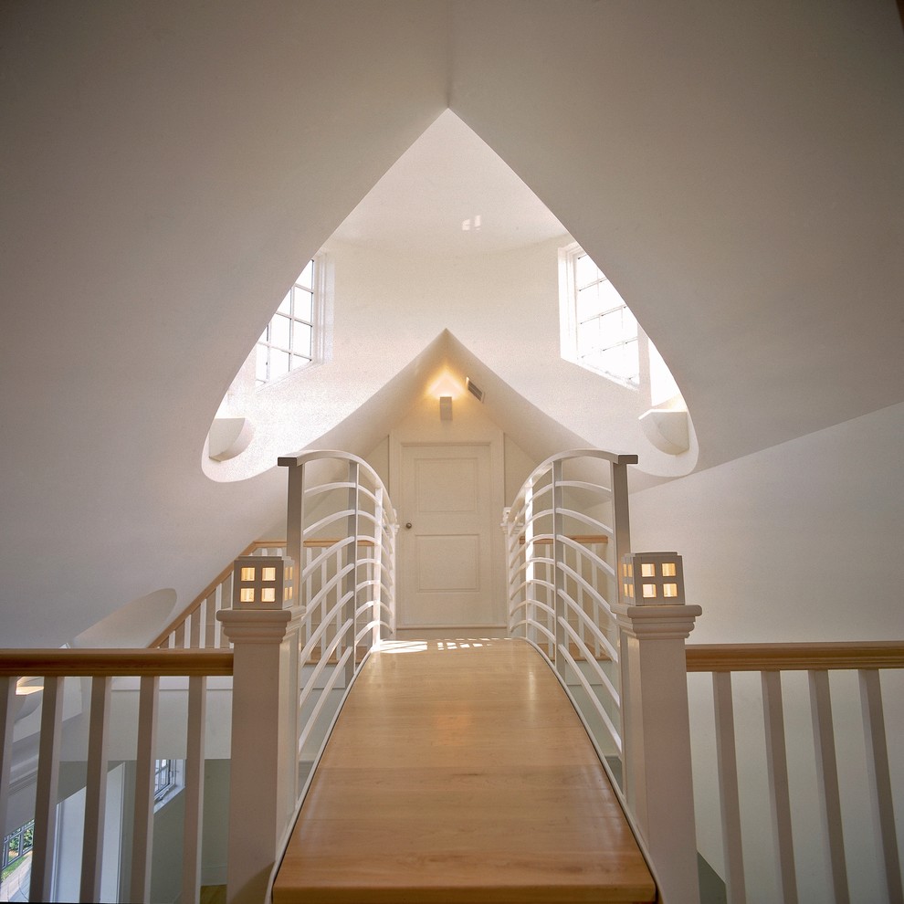 This is an example of a large beach style hallway in New York with white walls and medium hardwood floors.