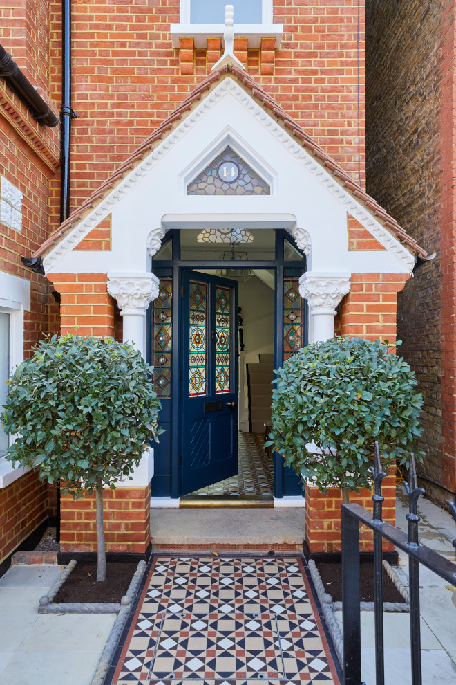 ロンドンにある広いヴィクトリアン調のおしゃれな玄関の写真