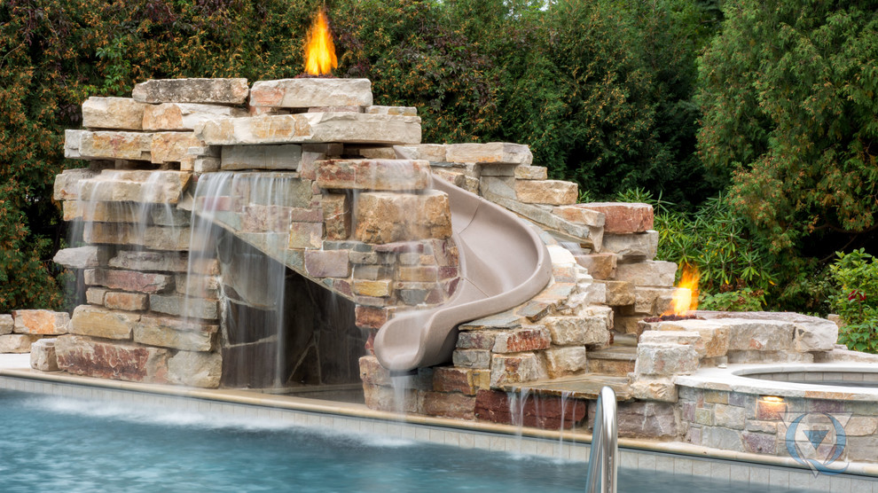 Large mountain style backyard rectangular lap water slide photo in Chicago