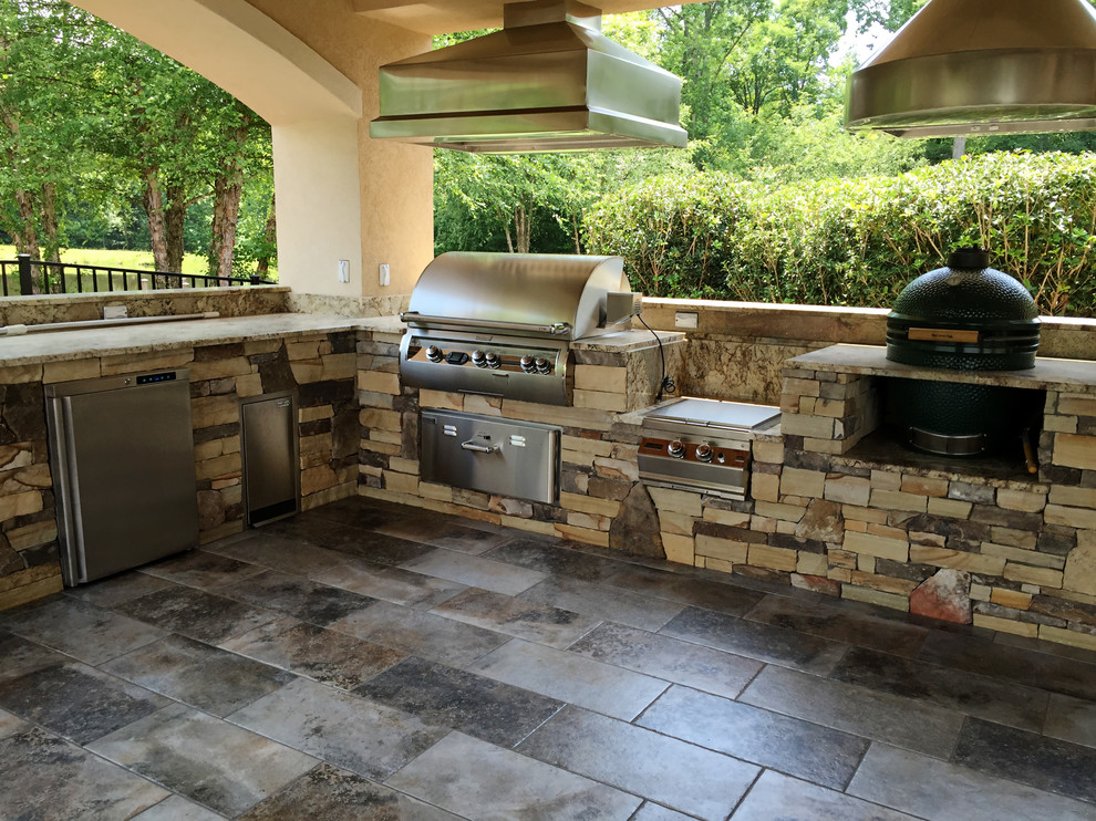 Inspiration for a large contemporary backyard patio in Other with an outdoor kitchen, tile and a roof extension.