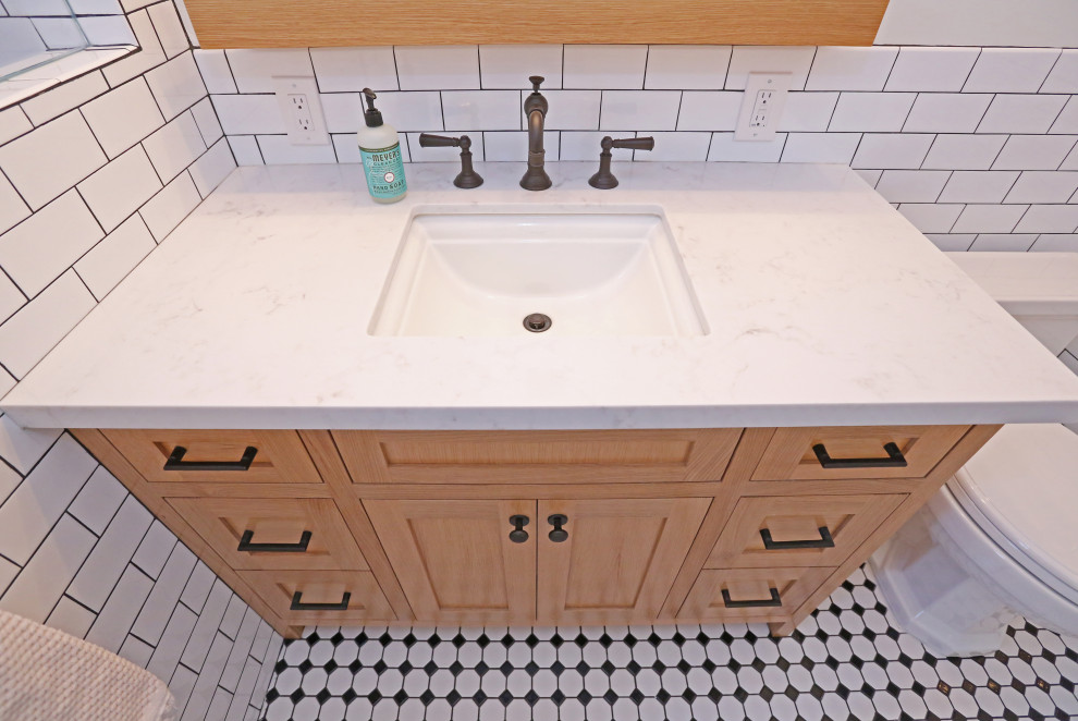 Exempel på ett mellanstort lantligt vit vitt badrum med dusch, med luckor med infälld panel, skåp i ljust trä, en dusch i en alkov, en toalettstol med hel cisternkåpa, vit kakel, cementkakel, beige väggar, klinkergolv i keramik, ett nedsänkt handfat, marmorbänkskiva, flerfärgat golv och med dusch som är öppen